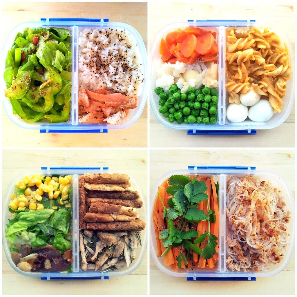 Four meal-prep containers packed with vegetables, pasta, rice and protein for lunch