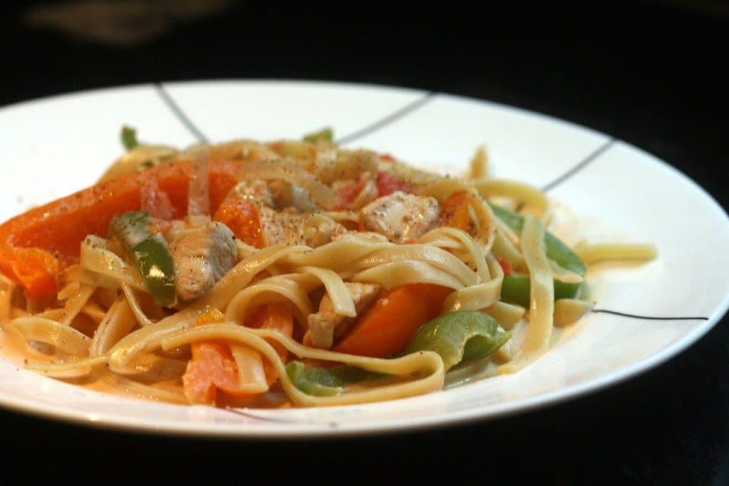Fettuccine with chicken, red, orange and green peppers in a light creamy sauce