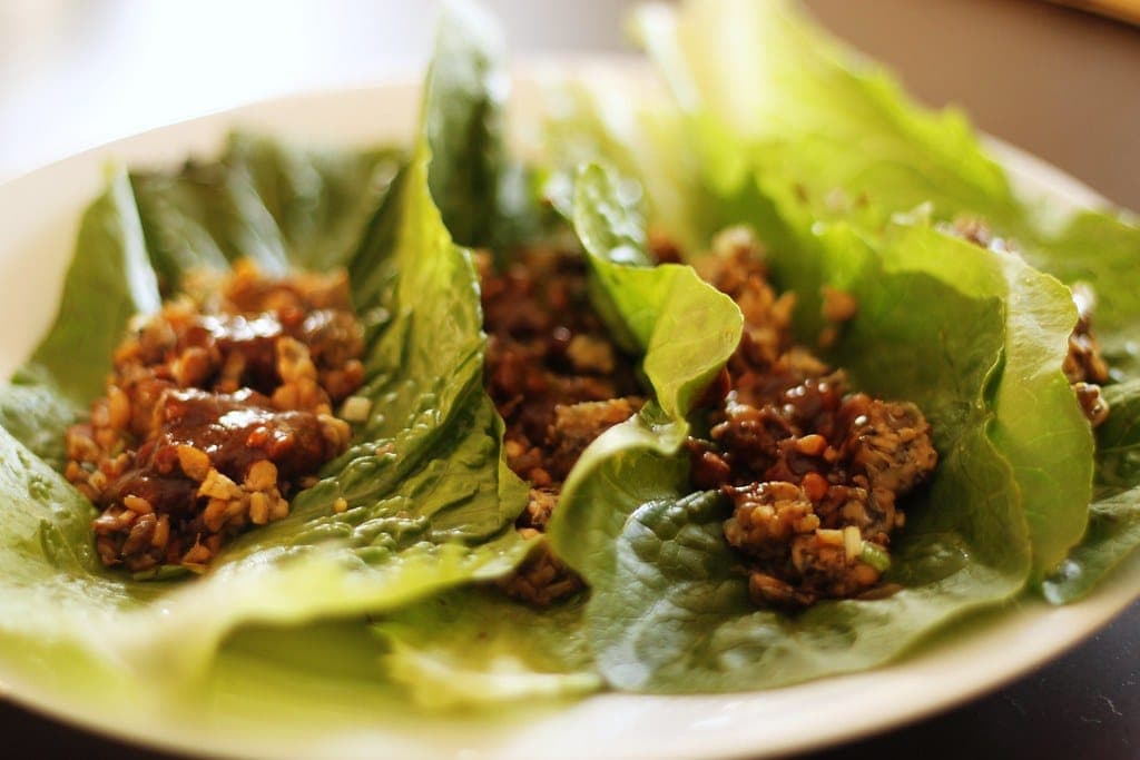Romaine lettuce cups filled with glossy, saucy minced chicken