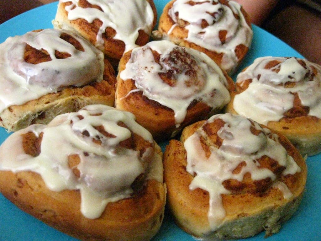 A pan of soft cinnamon rolls covered in white icing