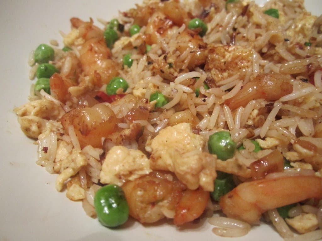 Close-up of fried rice with scrambled egg, green peas and shrimp