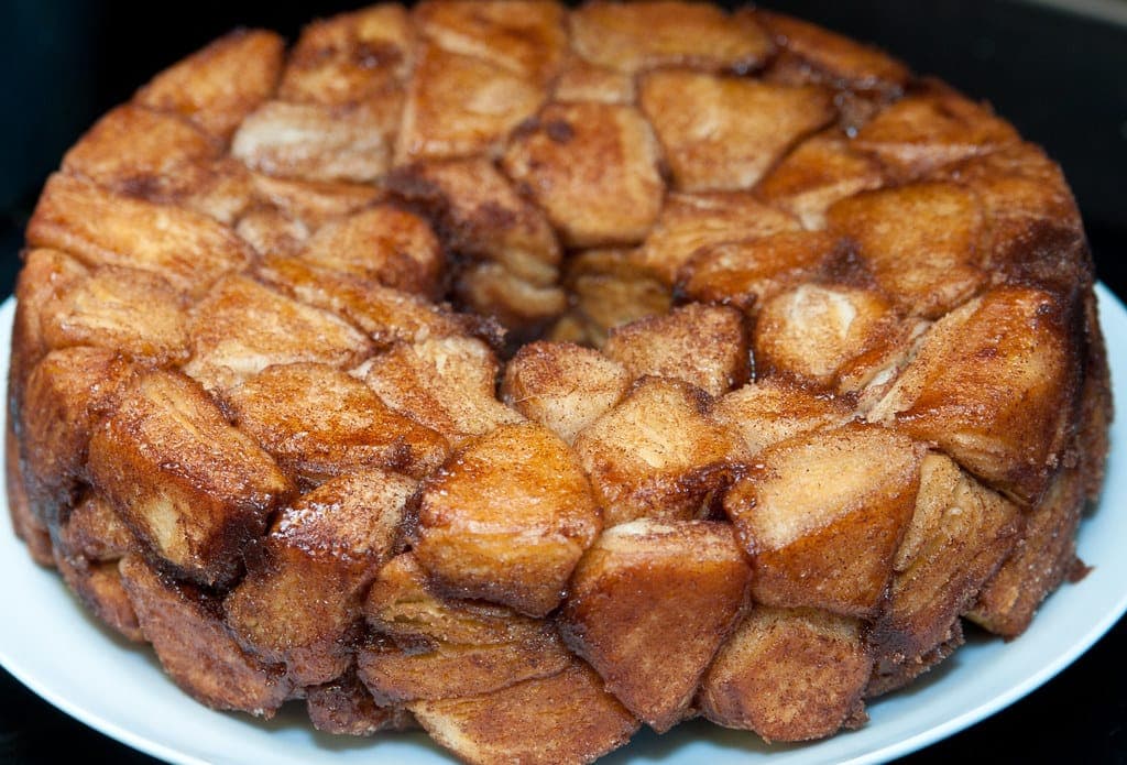 A caramelised monkey bread turned out onto a plate, showing its pull-apart pieces