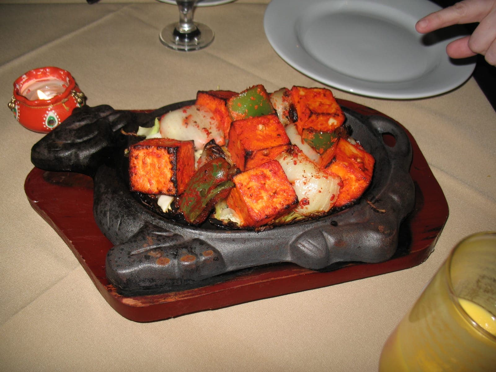 Paneer tikka with charred peppers and onion served on a cast-iron sizzler plate