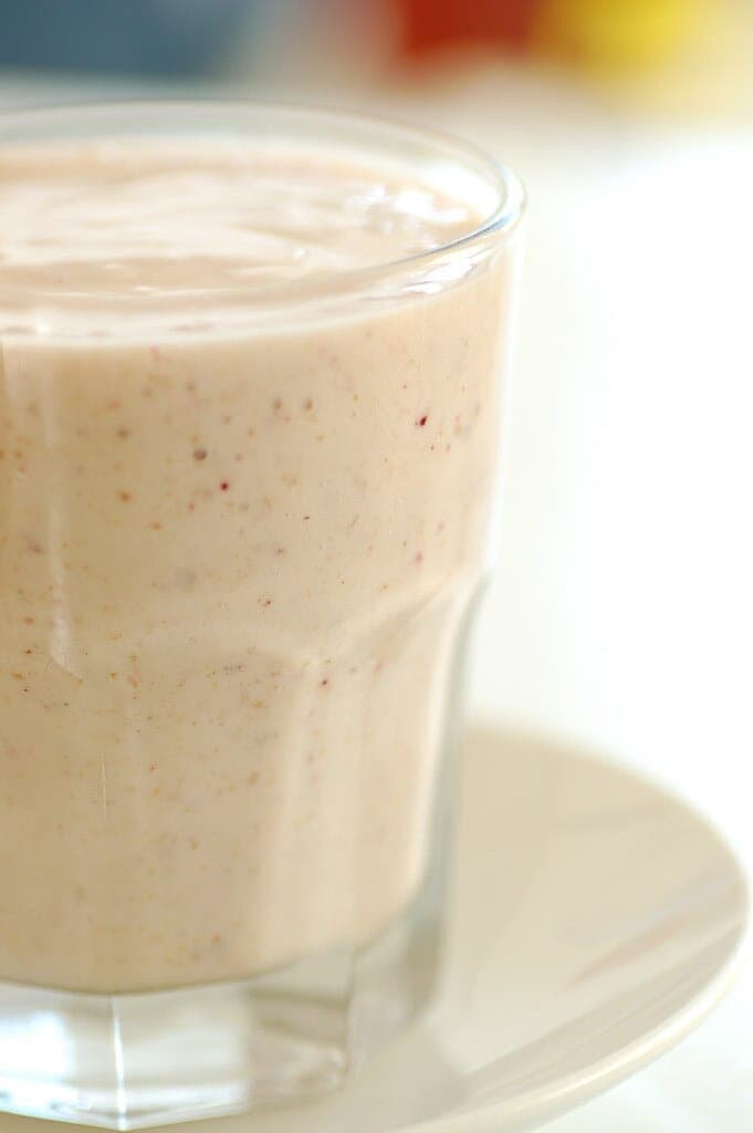 A tall glass of creamy, pale banana smoothie