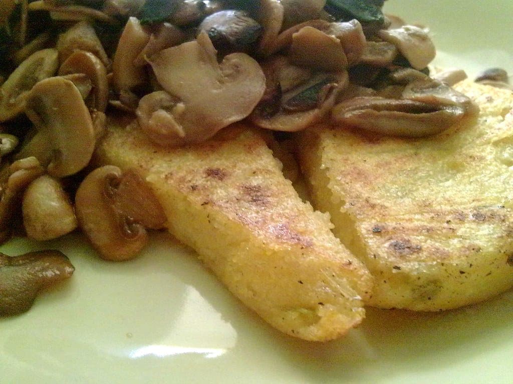 Seared slices of polenta topped with sautéed button mushrooms