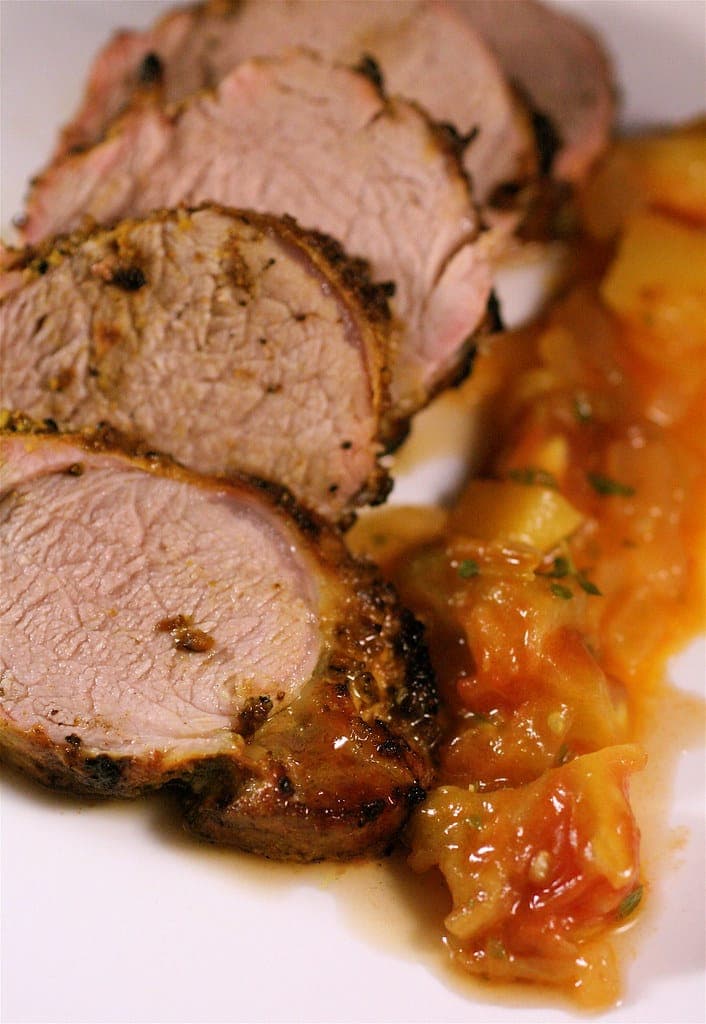 Sliced herb-crusted roasted pork tenderloin with a fruit chutney