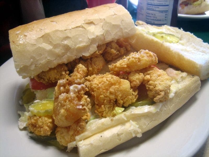Shrimp po' boy on French bread loaded with fried shrimp, lettuce, tomato and sauce