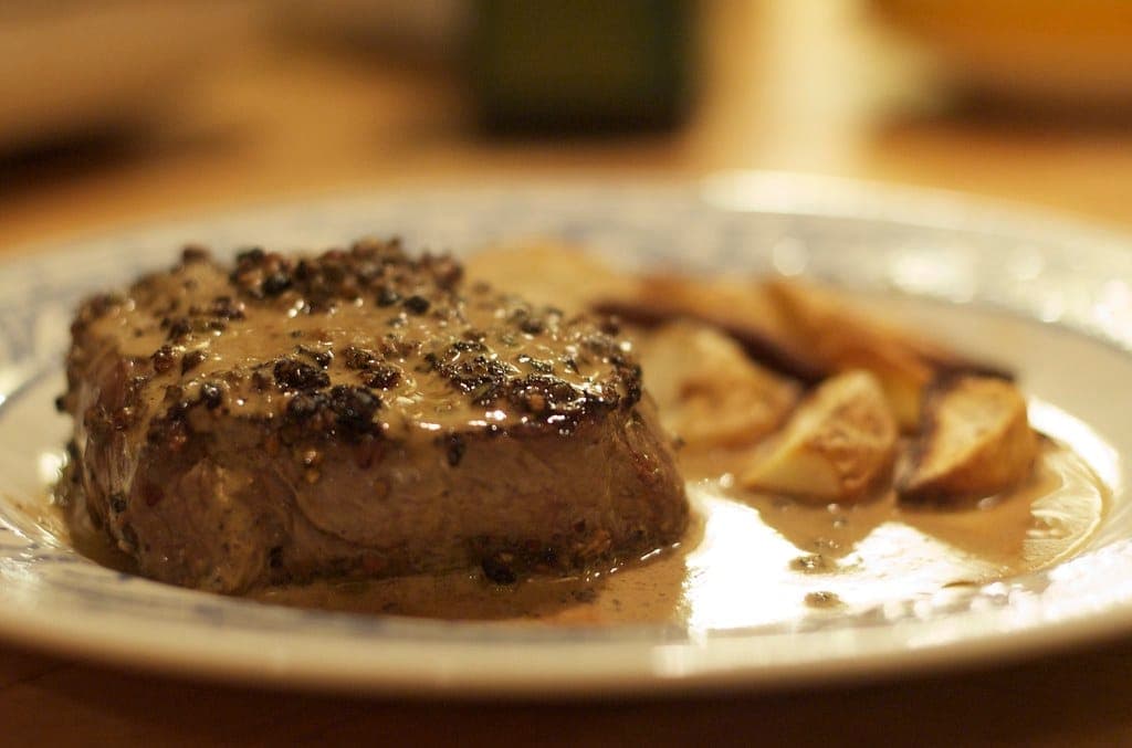 Thick peppercorn-crusted steak in a creamy pepper sauce with roasted potatoes